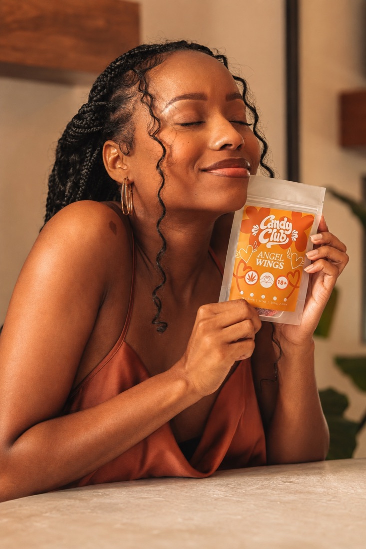 Someone enjoying a pack of Candy Club Angel Wings gummies